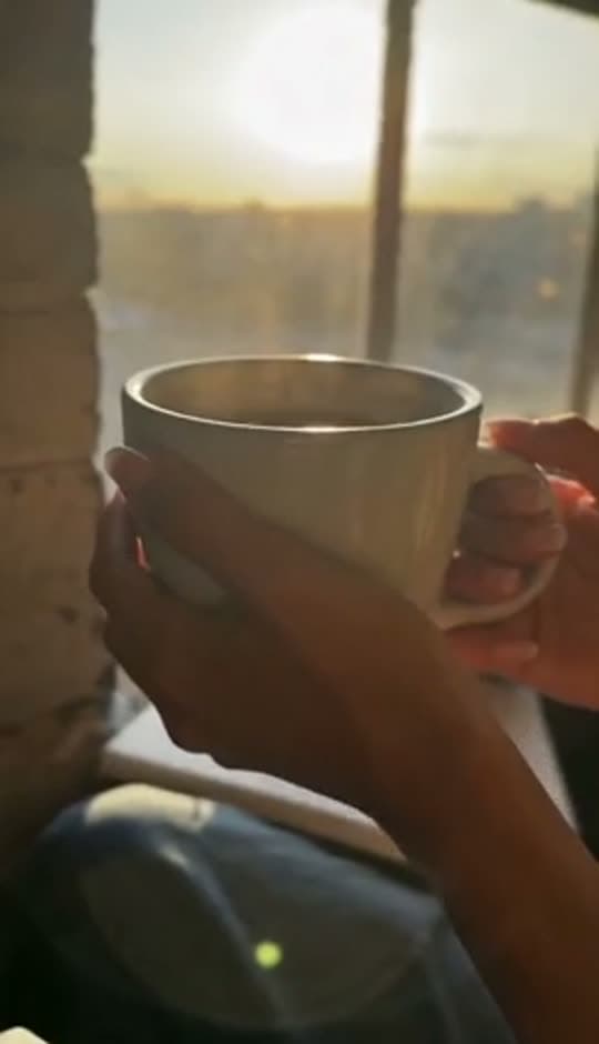 A mug of coffee at sunrise